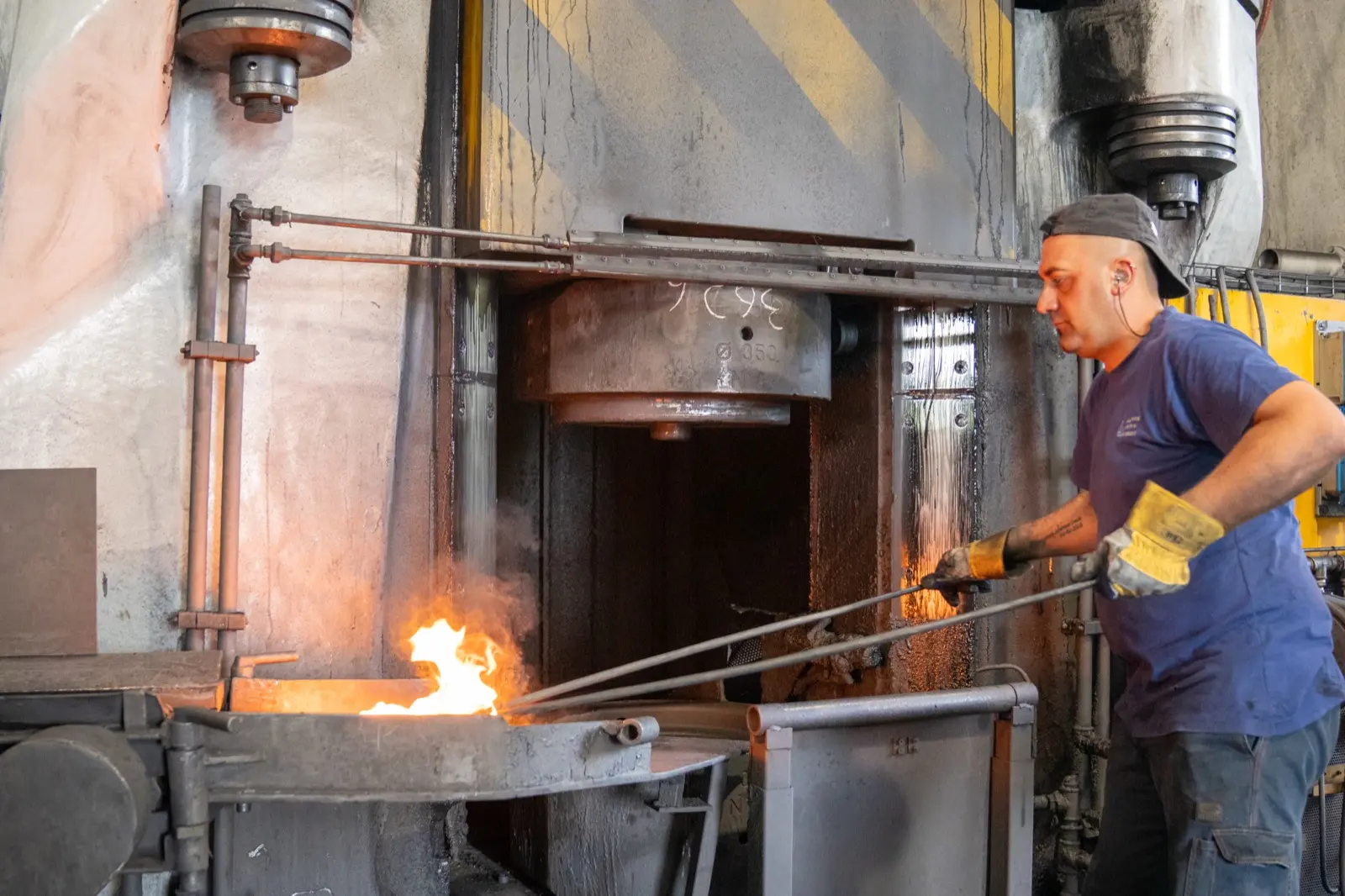 Operator with tongs in front of the furnace