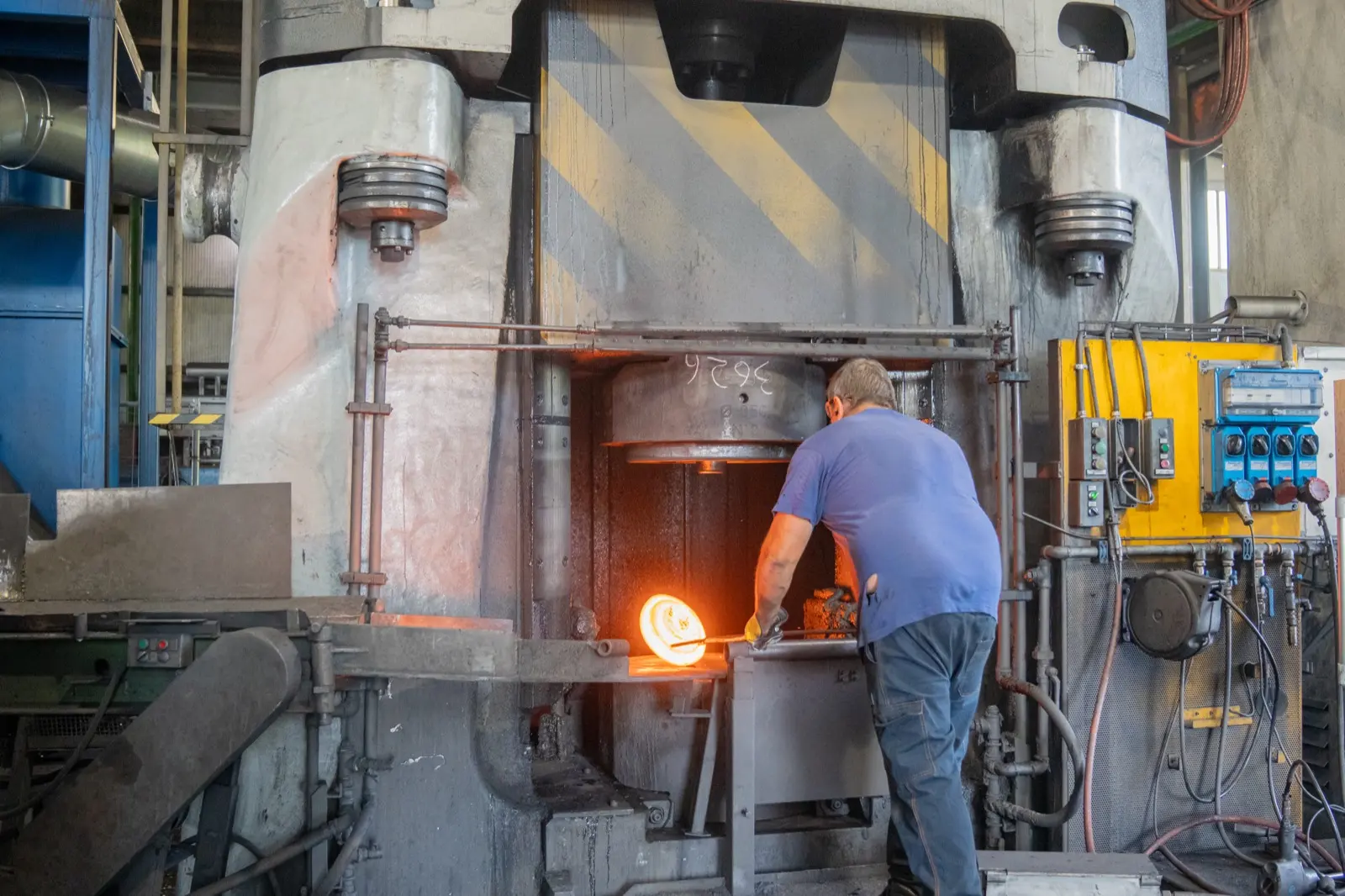Operator at the press with a glowing part