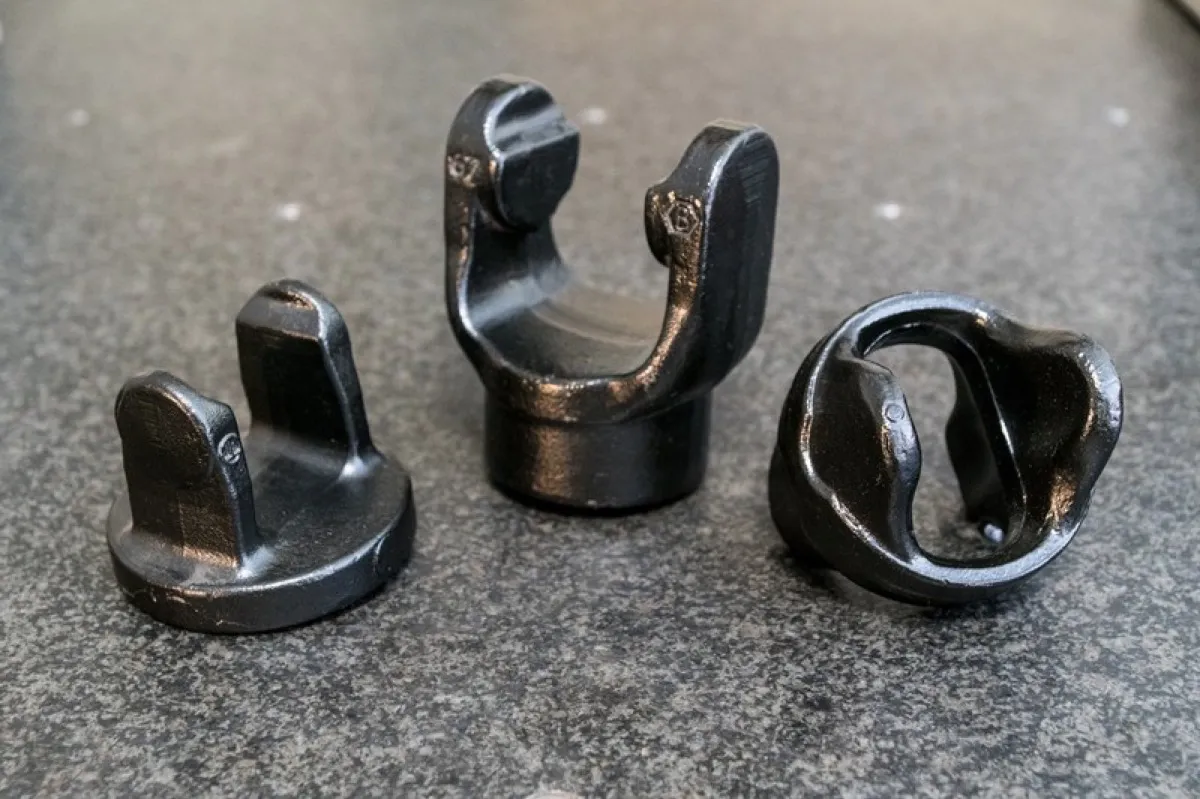 Three black forged yokes
